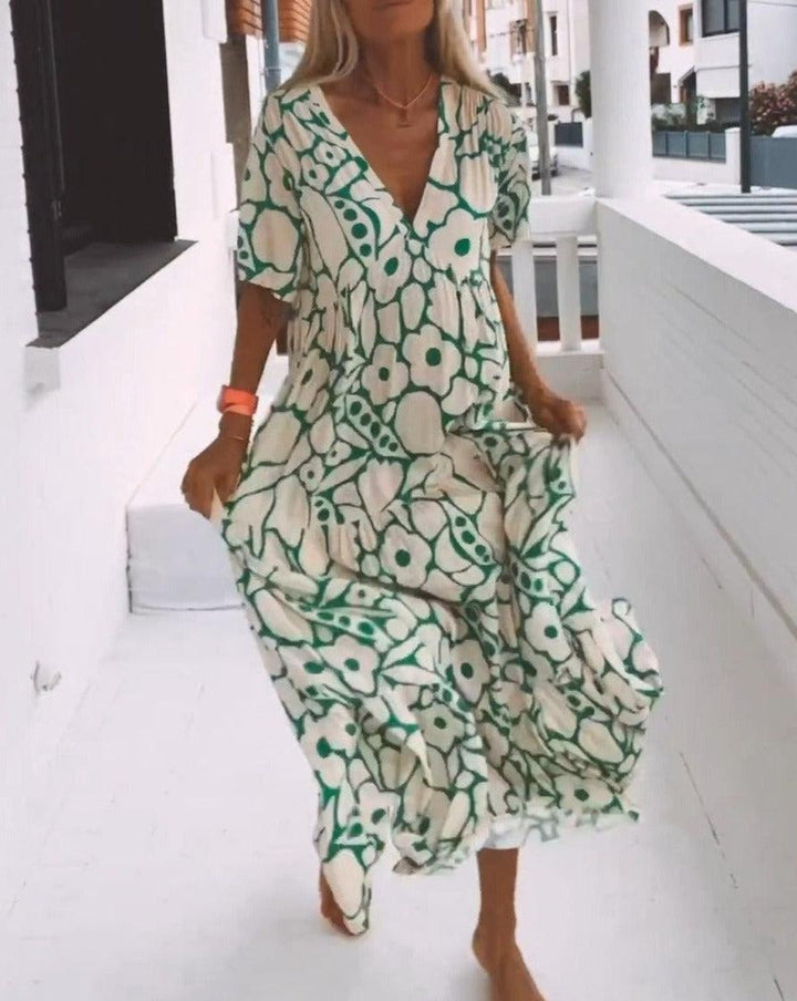 Robe longue fluide avec imprimé floral vert, manches courtes volantées et décolleté en V, idéale pour l'été.