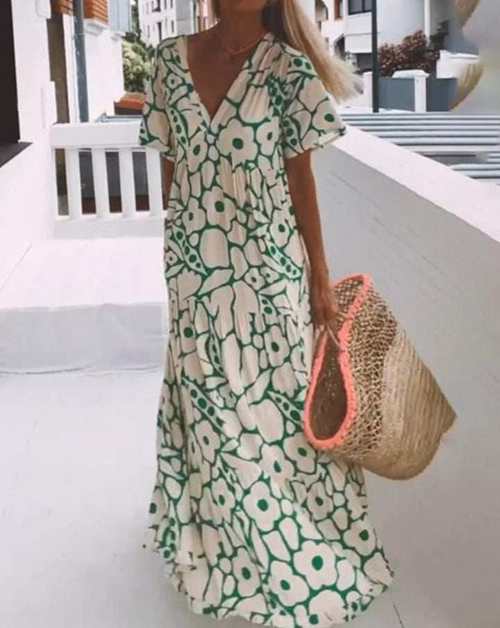 Robe longue fluide avec imprimé floral vert, manches courtes volantées et décolleté en V, idéale pour l'été.