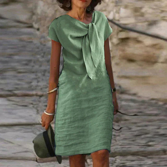 "Robe mi-longue en lin, nœud élégant au col, style décontracté chic, idéale pour jours ensoleillés."