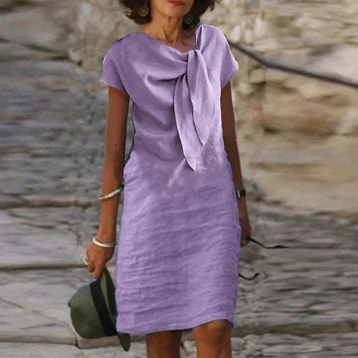 "Robe mi-longue en lin, nœud élégant au col, style décontracté chic, idéale pour jours ensoleillés."