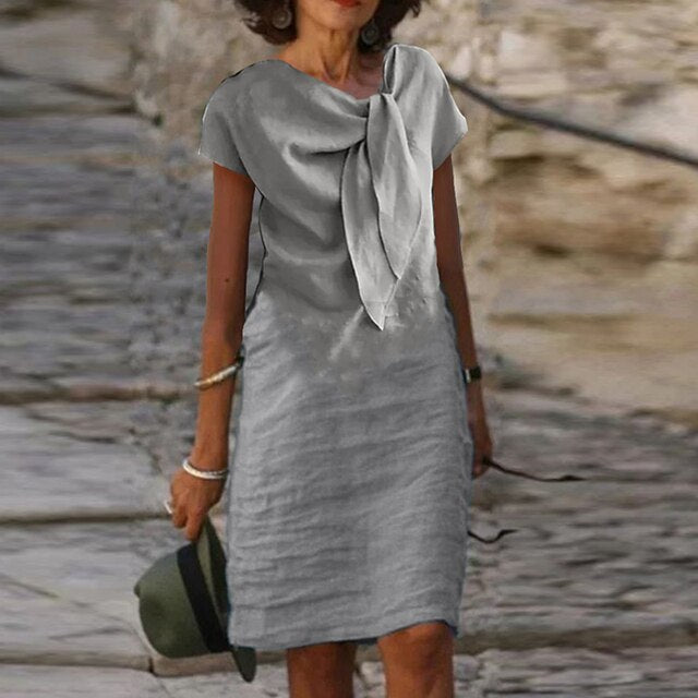 "Robe mi-longue en lin, nœud élégant au col, style décontracté chic, idéale pour jours ensoleillés."