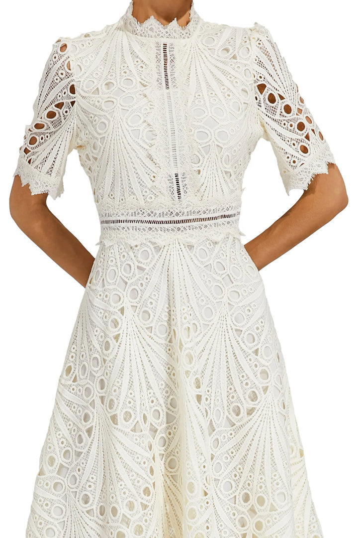 "Robe midi en dentelle blanche élégante, idéale pour mariages et soirées, avec encolure délicate et coupe raffinée."