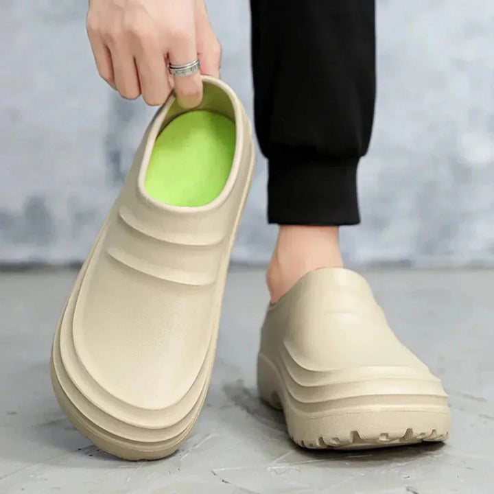 "Sabots antidérapants imperméables pour homme, semelle caoutchouc, sangle réglable, design sobre et élégant."