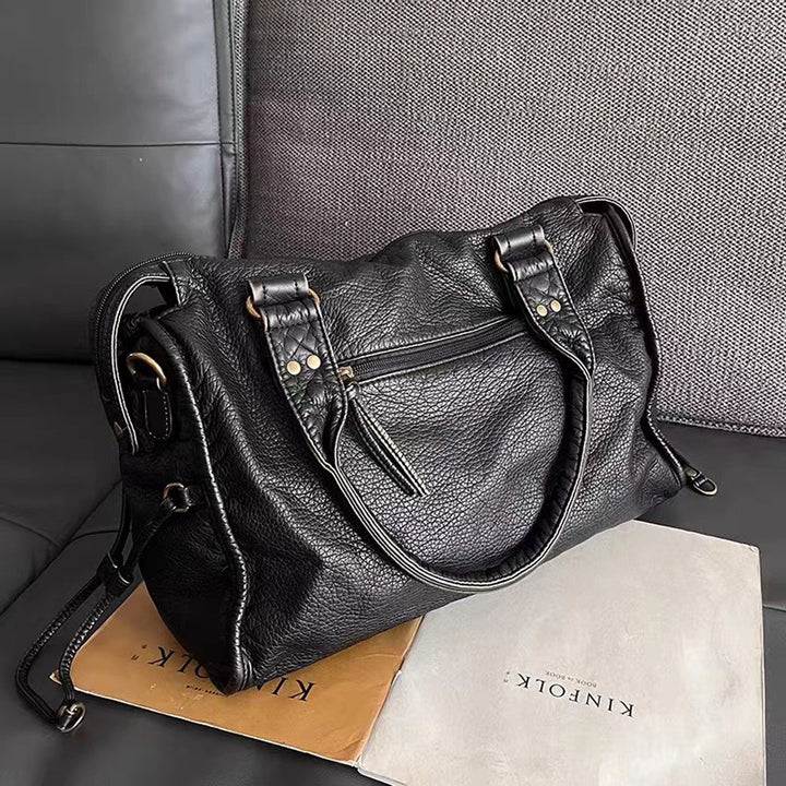 "Sac à main noir chic avec finitions dorées, bandoulière réglable et poches multiples pour une organisation élégante."