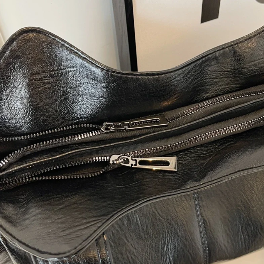 "Sac Amber en cuir végétal marron avec bandoulière, détails métalliques et poches, design élégant et spacieux pour femme."