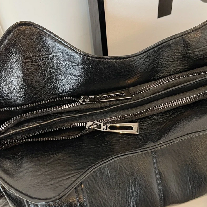 "Sac Amber en cuir végétal marron avec bandoulière, détails métalliques et poches, design élégant et spacieux pour femme."