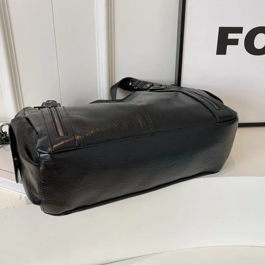 "Sac Amber en cuir végétal marron avec bandoulière, détails métalliques et poches, design élégant et spacieux pour femme."
