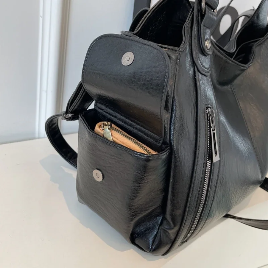 "Sac Amber en cuir végétal marron avec bandoulière, détails métalliques et poches, design élégant et spacieux pour femme."