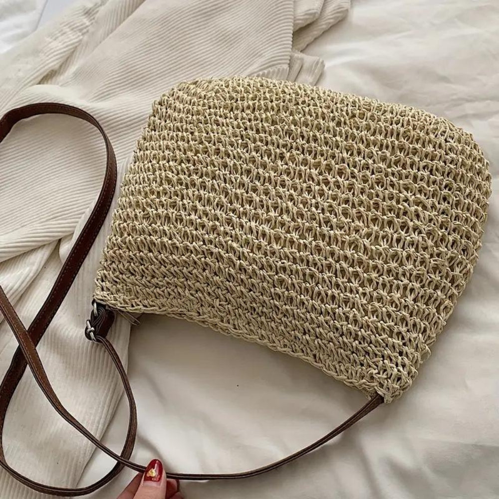 "Sac bandoulière Léandre en paille premium avec finitions cuir végan, bandoulière ajustable et fermeture éclair sécurisée."