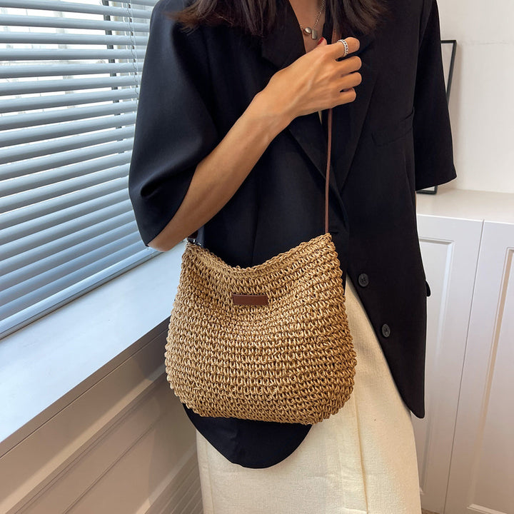 "Sac bandoulière Léandre en paille premium avec finitions cuir végan, bandoulière ajustable et fermeture éclair sécurisée."