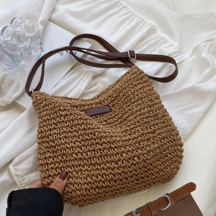 "Sac bandoulière Léandre en paille premium avec finitions cuir végan, bandoulière ajustable et fermeture éclair sécurisée."