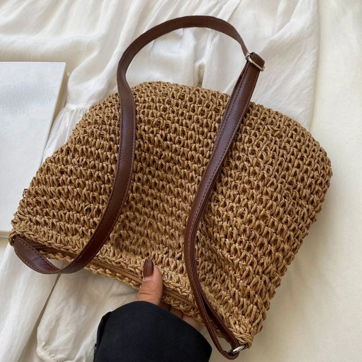 "Sac bandoulière Léandre en paille premium avec finitions cuir végan, bandoulière ajustable et fermeture éclair sécurisée."