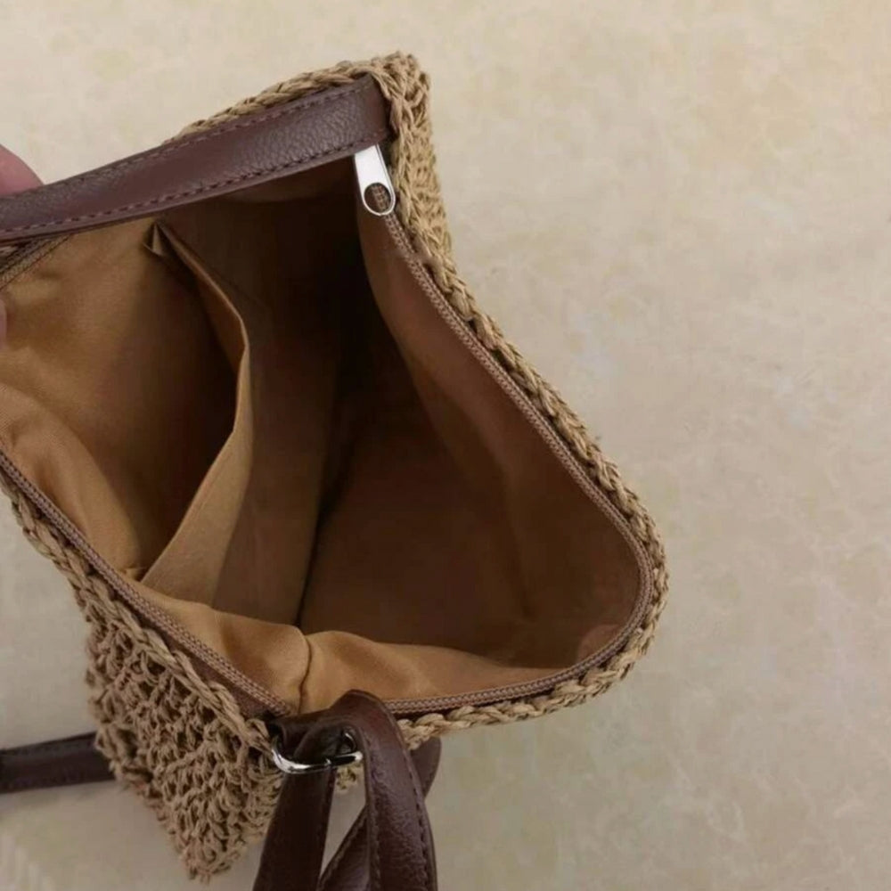 "Sac bandoulière Léandre en paille premium avec finitions cuir végan, bandoulière ajustable et fermeture éclair sécurisée."