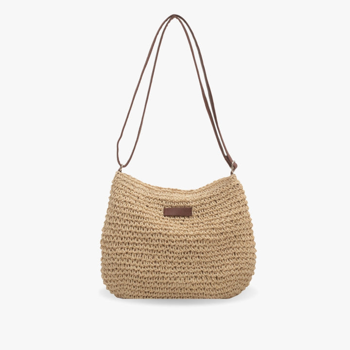 "Sac bandoulière Léandre en paille premium avec finitions cuir végan, bandoulière ajustable et fermeture éclair sécurisée."