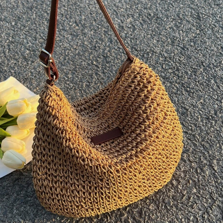 "Sac bandoulière Léandre en paille premium avec finitions cuir végan, bandoulière ajustable et fermeture éclair sécurisée."