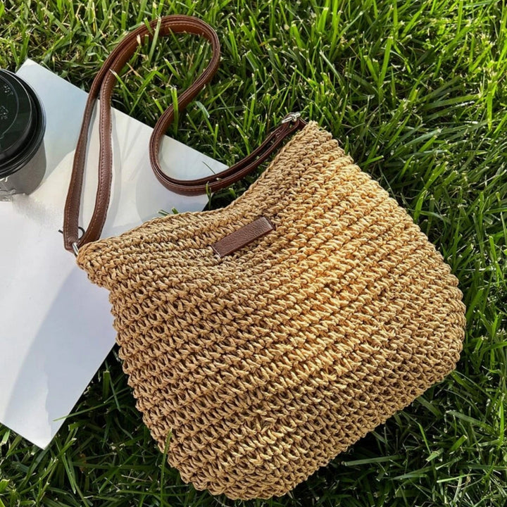 "Sac bandoulière Léandre en paille premium avec finitions cuir végan, bandoulière ajustable et fermeture éclair sécurisée."