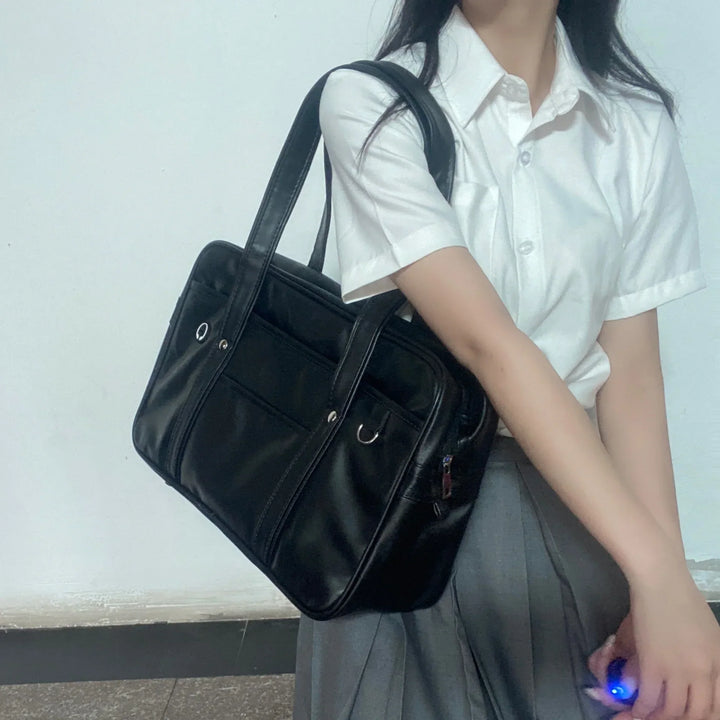Sac cabas stylé pour lycéennes, cuir PU noir, spacieux, avec compartiment ordinateur portable et poches pratiques.