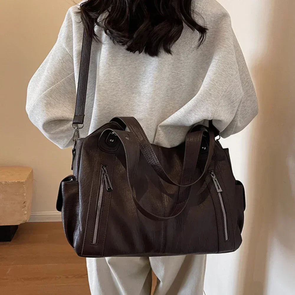 Sac d'école à bandoulière en cuir végétal lisse, design élégant, couleur classique, idéal pour femmes modernes.
