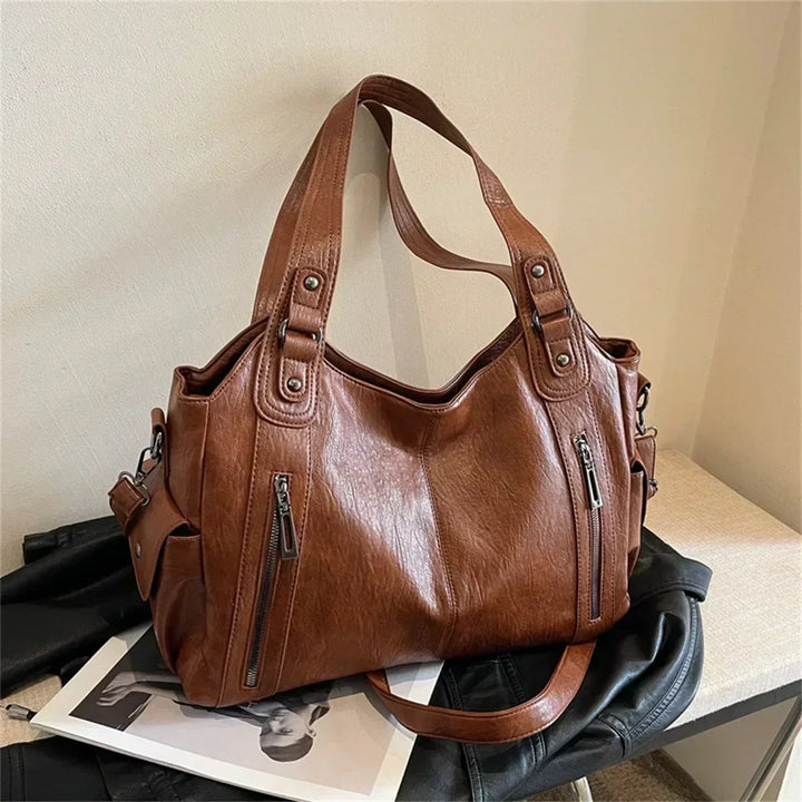Sac d'école à bandoulière en cuir végétal lisse, design élégant, couleur classique, idéal pour femmes modernes.