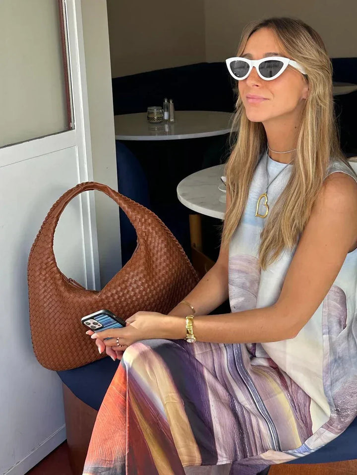 Sac hobo en cuir synthétique bordeaux tressé, élégant et spacieux, avec anse souple et fermeture éclair sécurisée.