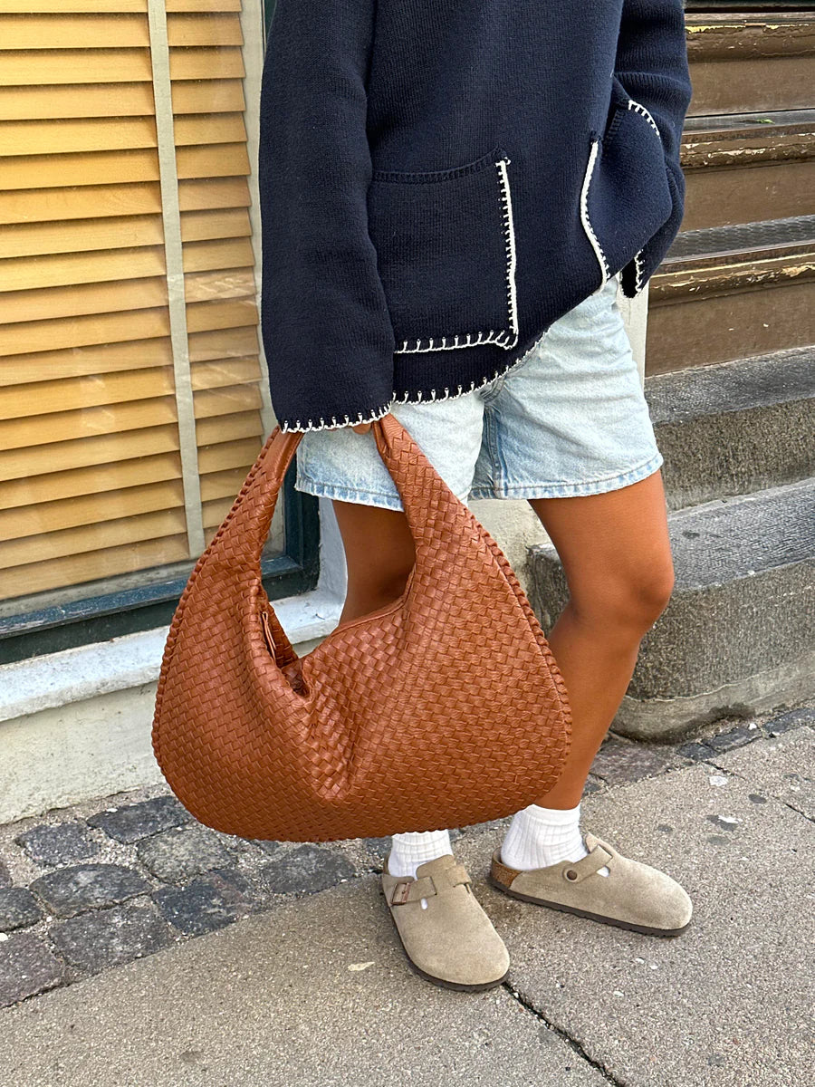 Sac hobo en cuir synthétique bordeaux tressé, élégant et spacieux, avec anse souple et fermeture éclair sécurisée.