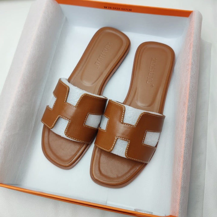Sandales H-Stylé pour femmes en cuir, design moderne en H, talon plat, couleur beige, élégance et confort pour l'été.
