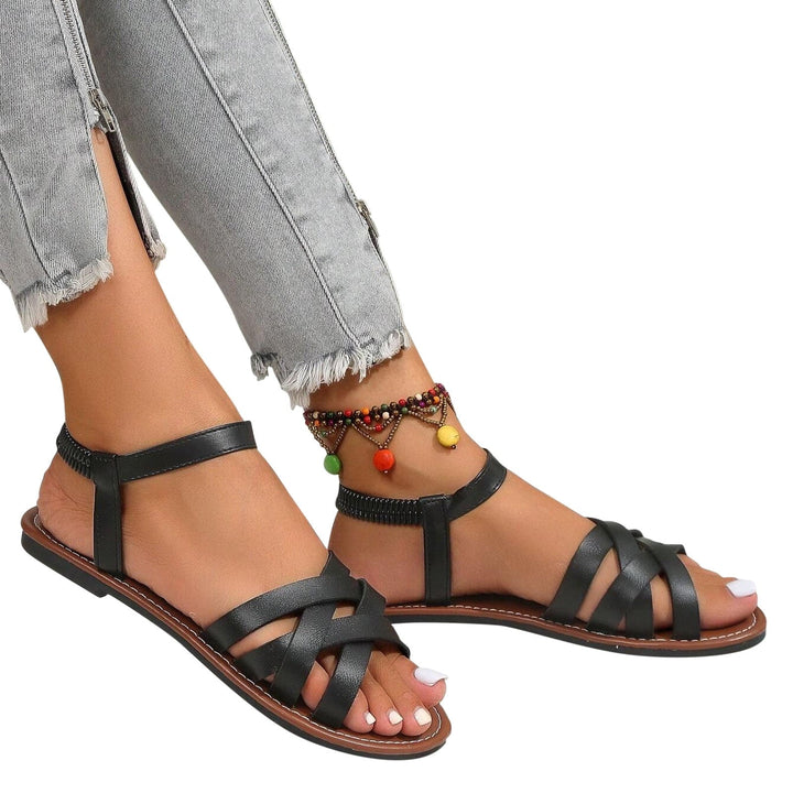 "Sandales plates femme à bandes croisées, couleur beige, idéales pour l'été, offrant confort et élégance pour la plage."
