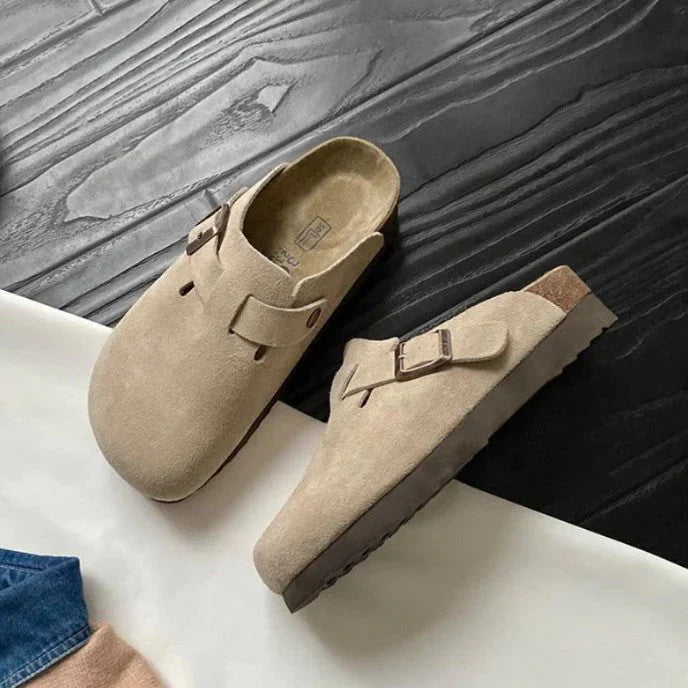 "Sandales unisexes élégantes en cuir beige sur fond de bois, style moderne et confort optimal."
