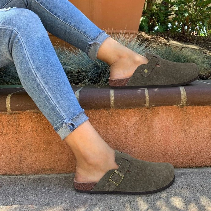 "Sandales unisexes élégantes en cuir beige sur fond de bois, style moderne et confort optimal."