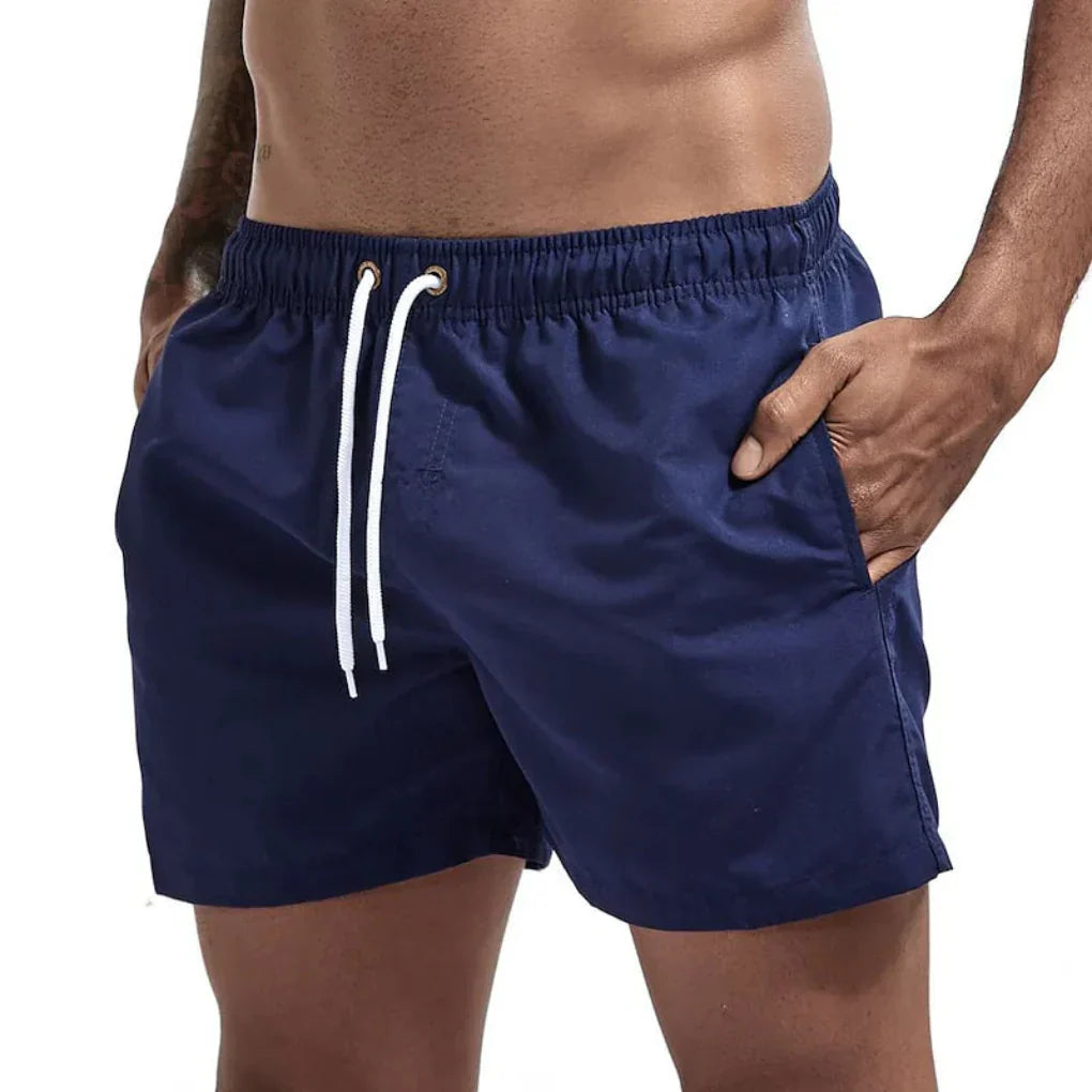 "Short de bain homme bleu clair, séchage rapide, doublure en mesh, poches latérales et arrière, ceinture élastique."