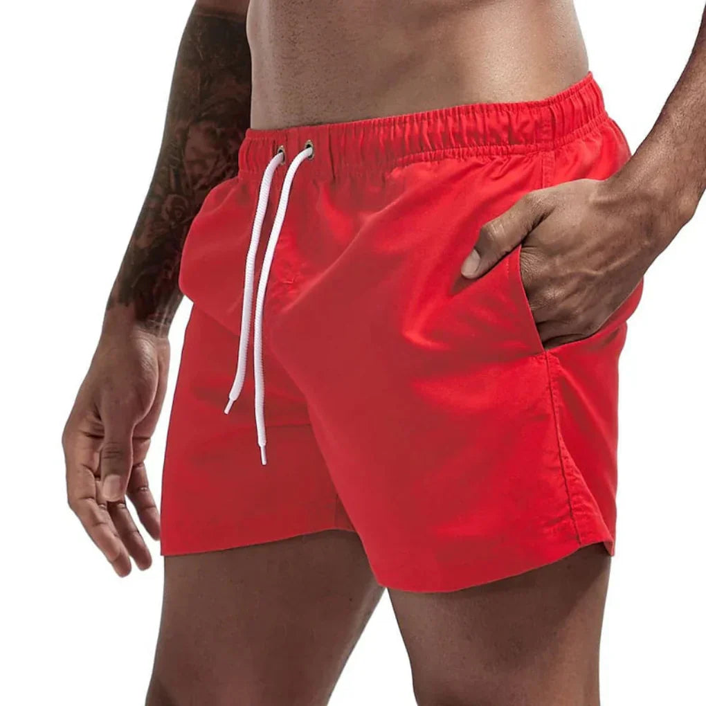 "Short de bain homme bleu clair, séchage rapide, doublure en mesh, poches latérales et arrière, ceinture élastique."