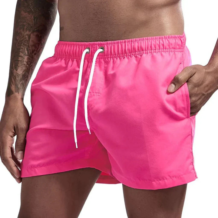 "Short de bain homme bleu clair, séchage rapide, doublure en mesh, poches latérales et arrière, ceinture élastique."