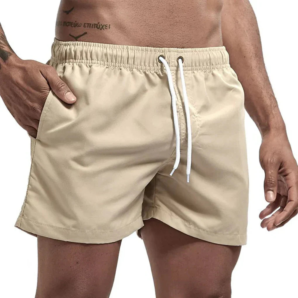 "Short de bain homme bleu clair, séchage rapide, doublure en mesh, poches latérales et arrière, ceinture élastique."