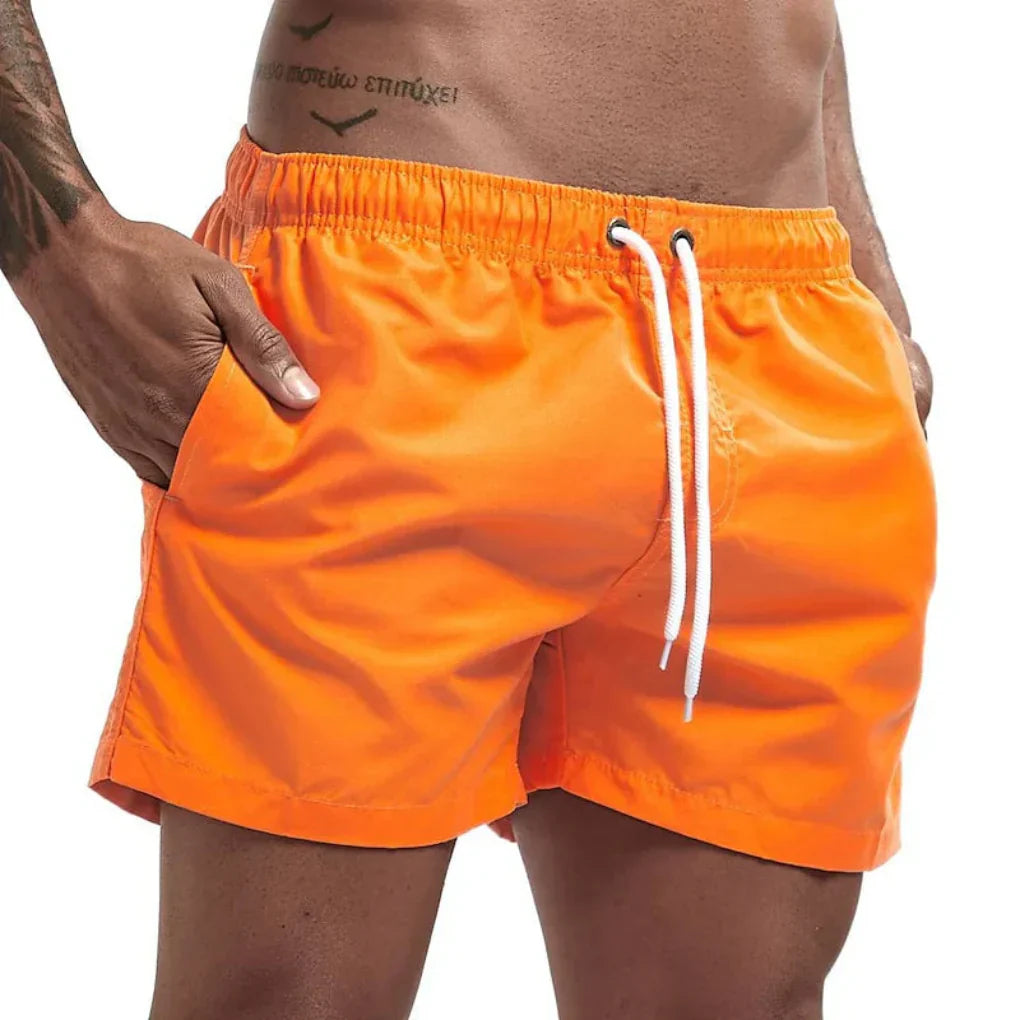 "Short de bain homme bleu clair, séchage rapide, doublure en mesh, poches latérales et arrière, ceinture élastique."