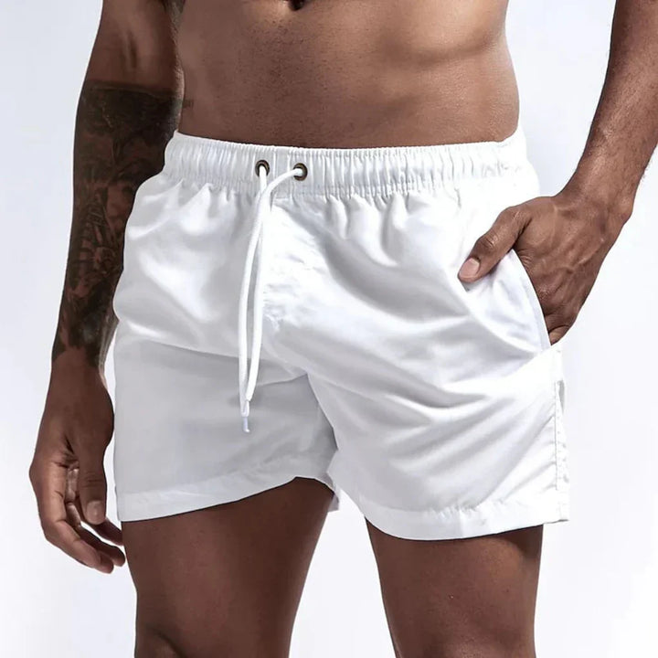 "Short de bain homme bleu clair, séchage rapide, doublure en mesh, poches latérales et arrière, ceinture élastique."