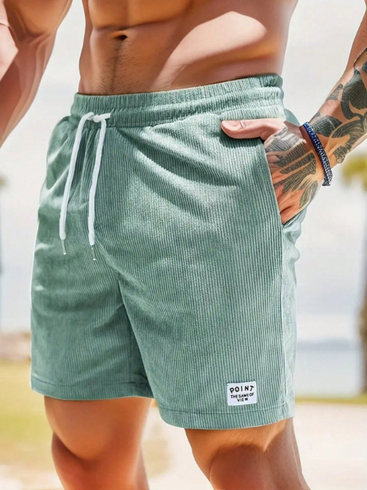 "Short en velours côtelé pour homme, coupe ample, couleur sombre, idéal pour l'été, alliant élégance et confort."