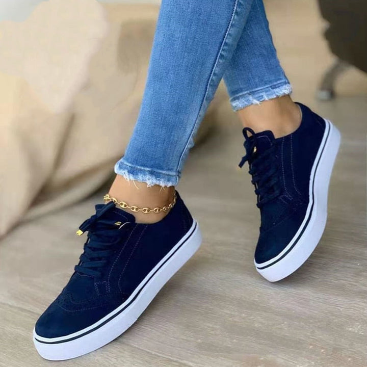 Sneakers orthopédiques élégantes pour femme en cuir blanc, avec semelle de soutien confortable et design moderne.