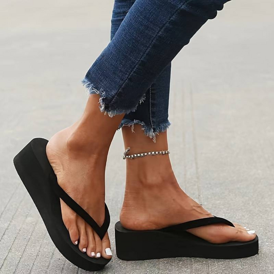 "Tongs femme compensées noires avec talon et semelle coussinée, bride souple, parfaites pour l'été."