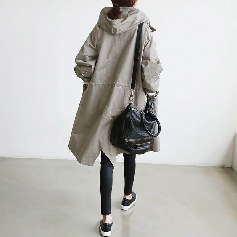 "Trench-coat imperméable femme élégant, beige, ceinture ajustable, matériaux durables, silhouette chic et pratique sous la pl