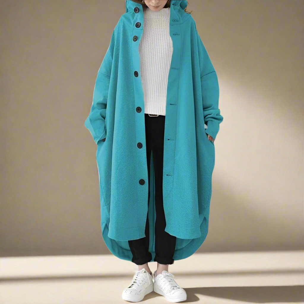 "Trench coat long femme Julina avec capuche, coupe ample et poches latérales, élégance chic pour un look décontracté."