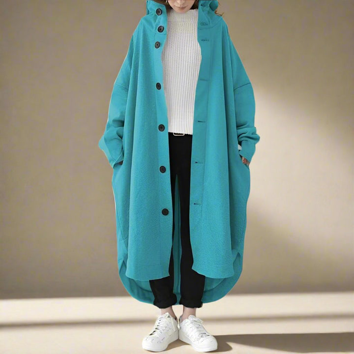 "Trench coat long femme Julina avec capuche, coupe ample et poches latérales, élégance chic pour un look décontracté."