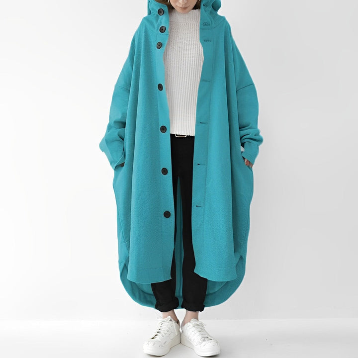 "Trench coat long femme Julina avec capuche, coupe ample et poches latérales, élégance chic pour un look décontracté."
